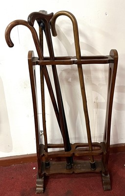 Lot 646 - A walnut twin division stickstand, of shaped...