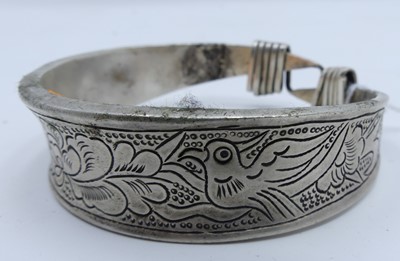 Lot 452 - A Chinese white metal bangle engraved with...