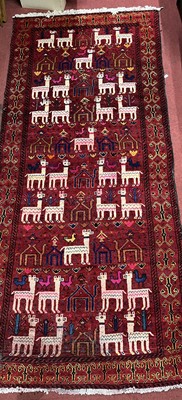 Lot 1172 - A Turkish woollen red ground hall rug, the...