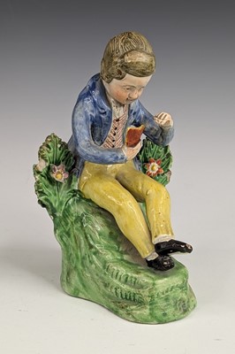 Lot 2064 - A Staffordshire pearlware figure of a boy...