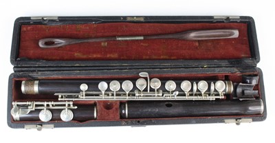 Lot 651 - A grenadilla flute with plated mounts in a...