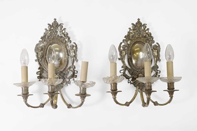 Lot 110 - A pair of silvered-brass wall lights, in the...