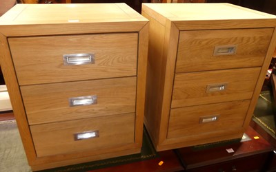 Lot 1177 - A pair of contemporary blond oak three drawer...