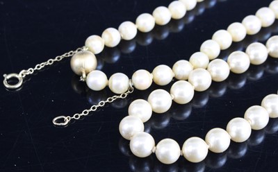 Lot 391 - A faux pearl single knotted string necklace,...