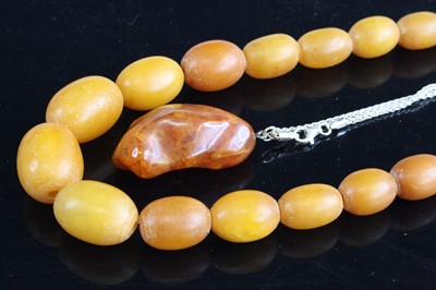 Lot 357 - A faux amber barrel bead necklace; together...