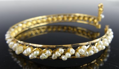 Lot 2286 - A yellow metal oval openwork bangle, having...