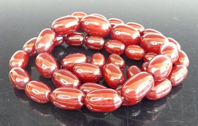 Lot 2303 - A cherry amber necklace, arranged as...