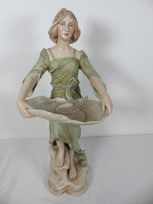 Lot 25 - A continental pottery figure of a lady, shown...