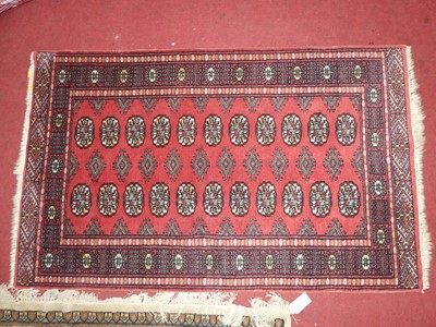 Lot 1167 - A Persian woollen red ground Bokhara rug, 150...