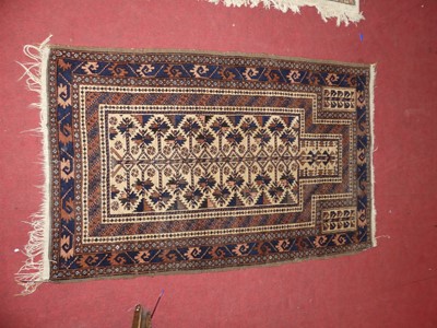 Lot 1168 - A Persian woollen cream ground Baluch rug, 140...