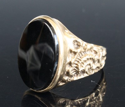 Lot 2555 - A 9ct yellow gold oval onyx signet ring. The...