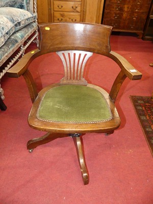 Lot 1358 - A 1930s oak splat back tub desk revolving...