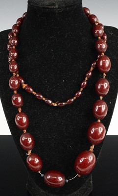 Lot 454 - A beaded and knotted cherry amber single...