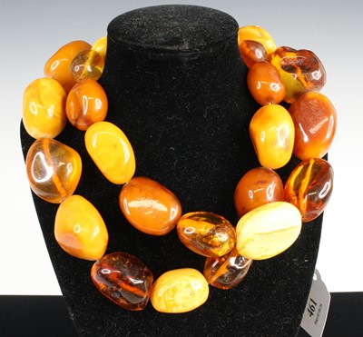 Lot 461 - An amber necklace, arranged as large...