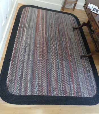 Lot 1258 - A braided woollen rug, decorated with long...