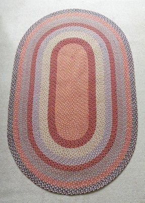 Lot 1255 - A contemporary braided oval rug, as radiating...
