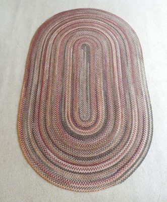 Lot 1257 - A contemporary braided oval rug, as radiating...