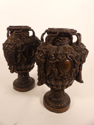 Lot 18 - A pair of bronzed metal urns, each having...