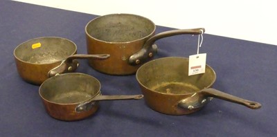 Lot 130 - A collection of four antique copper saucepans,...