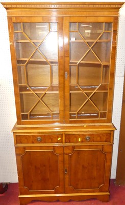 Lot 1150 - A reproduction yew bookcase cupboard, having...