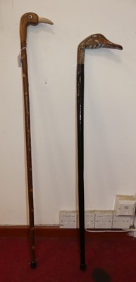 Lot 405 - Two walking sticks, the handle of each carved...