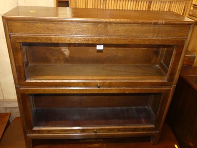 Lot 1381 - A 1930s oak two-tier stacking bookcase, having...