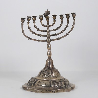 Lot 269 - A white metal menorah, repousse decorated with...