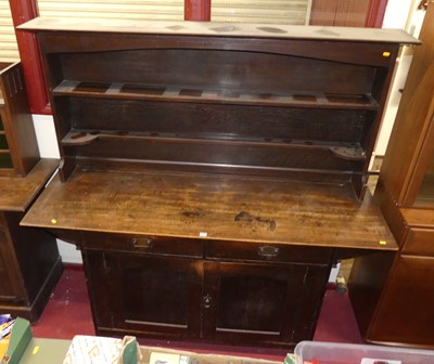 Lot 1139 - An Arts & Crafts oak dresser, the two-tier...