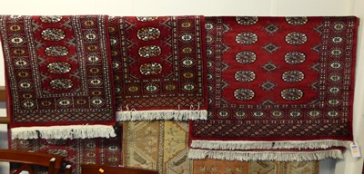 Lot 1152 - A Persian woollen red ground Bokhara rug;...