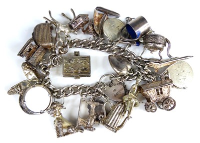 Lot 2755 - A silver charm bracelet containing a wide...