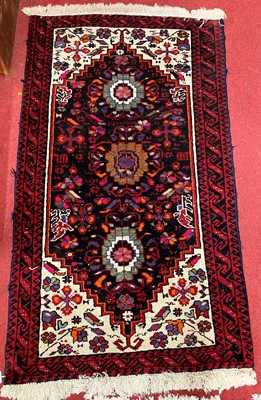 Lot 1160 - A Persian woollen red ground Yalameh hall rug,...