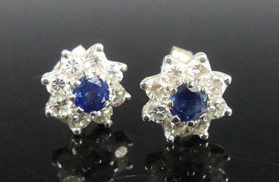 Lot 2248 - A pair of white metal diamond flower cluster...