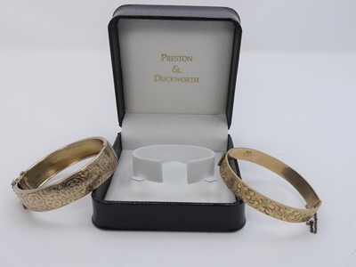 Lot 353 - A 20th century rolled gold hinged bangle, with...