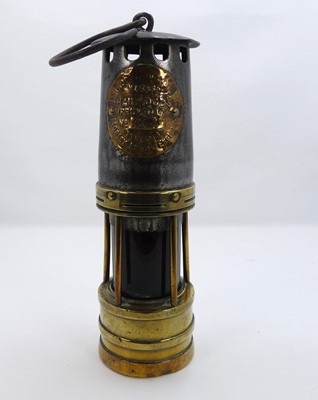 Lot 242 - A vintage miner's lamp bearing a label for...