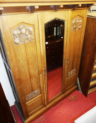 Lot 1141 - An Arts & Crafts oak triple wardrobe, having...