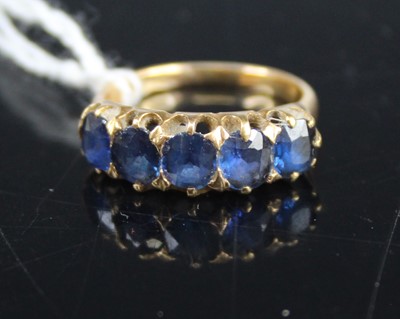 Lot 432 - A yellow metal and sapphire set half-hoop ring,...