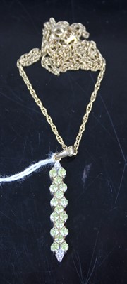 Lot 427 - A modern 9ct gold and peridot set bar pendant,...