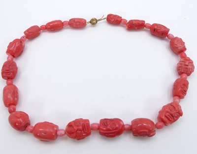 Lot 311 - A dyed and carved coral long necklace, each...