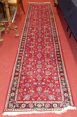 Lot 1178 - A Persian woollen Keshan red ground long hall...