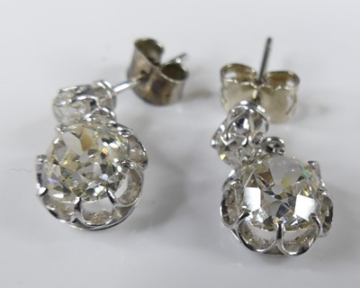 Lot 2276 - A pair of white metal diamond drop earrings,...