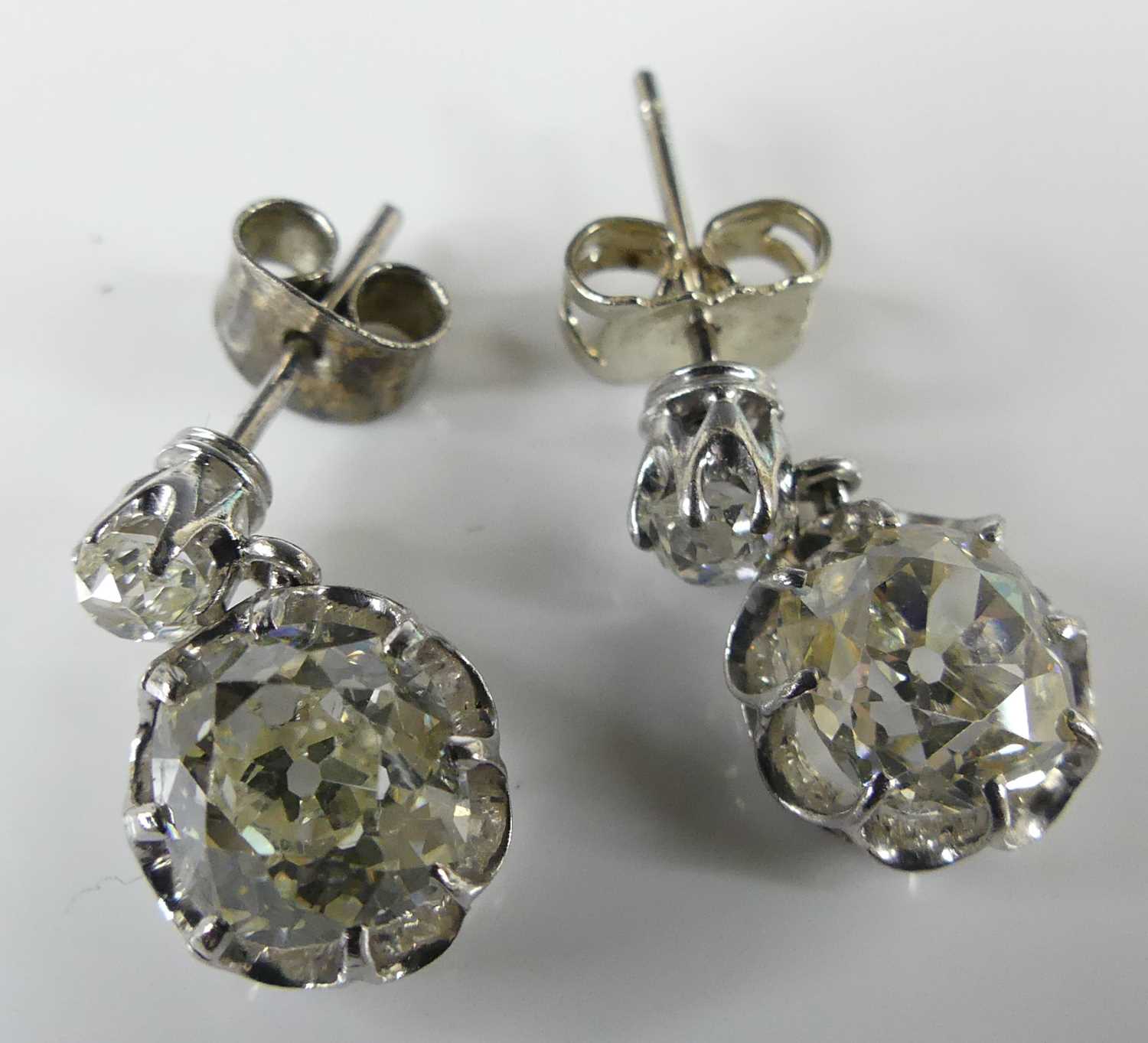 Lot 2276 - A pair of white metal diamond drop earrings,...