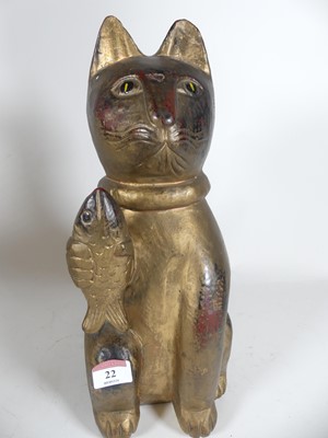 Lot 22 - A carved wooden figure of a cat holding a fish,...