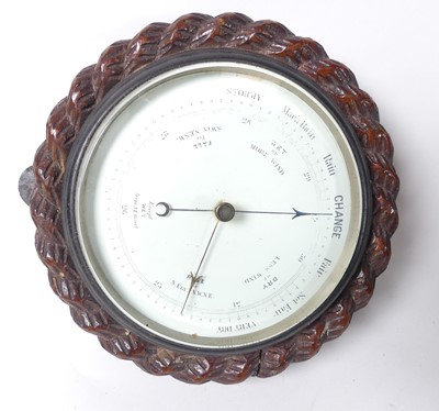 Lot 43 - A barometer with carved oak frame