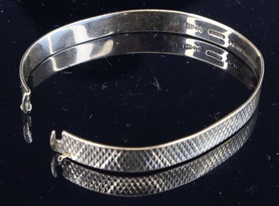 Lot 336 - A 9ct gold and engine turned expanding bangle,...