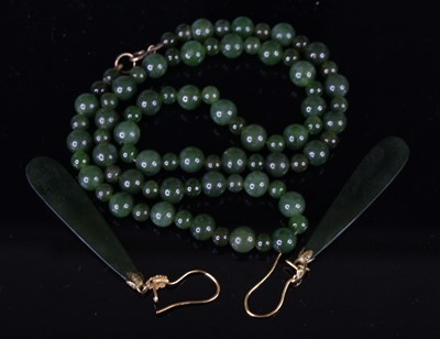 Lot 405 - A beaded spinach jade necklace, 46cm; together...