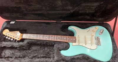 Lot 663 - A turquoise Stratocaster electric guitar in...