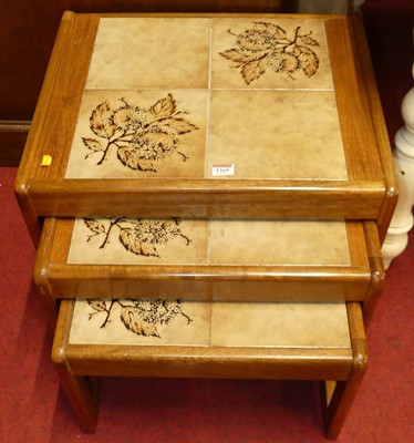 Lot 1269 - A 1970s teak and tile inset nest of three...