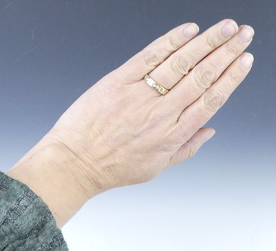 Lot 2549 - A yellow metal diamond half eternity ring,...