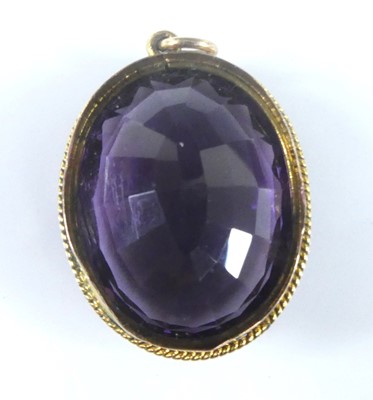 Lot 2583 - A yellow metal oval amethyst pendant, the...