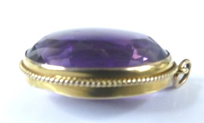 Lot 2583 - A yellow metal oval amethyst pendant, the...
